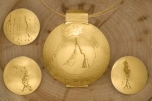 Meisterstück aus 750er Gelbgold mit geschmiedeter Oberfläche und vier auswechselbaren Granulationselementen. Medaillon mit Sprungdeckelmechanik zum Öffnen von Vorder- und Rückseite.