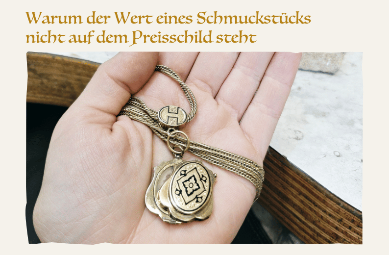 Eine Hand hält ein altes Medaillon an einer Kette auf einer Werkbank. Das Schmuckstück zeigt sichtbare Gebrauchsspuren und steht sinnbildlich für Erinnerungen, Geschichten und den ideellen Wert von Schmuck.